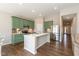 Modern kitchen with a large island, hardwood floors, stainless steel appliances, and bright green cabinetry at 1483 Paper Birch Dr, Sheridan, IN 46069