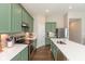 Modern kitchen showcasing stainless steel appliances and green cabinets and quartz countertops at 1483 Paper Birch Dr, Sheridan, IN 46069