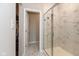 Luxurious shower with a glass door and marble tiling, plus a view of a walk-in closet at 1483 Paper Birch Dr, Sheridan, IN 46069