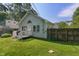 Charming light-blue home with a well-manicured lawn, a small deck, and a surrounding wooden fence at 1802 E 66Th St, Indianapolis, IN 46220