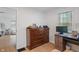 A bedroom featuring wood dresser, desk, and a sunlit window providing natural light to the room at 1802 E 66Th St, Indianapolis, IN 46220