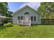 Charming light-blue home with a well-manicured front yard, a small porch, and surrounding wooden fence at 1802 E 66Th St, Indianapolis, IN 46220