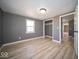 Bright bedroom with light wood-look flooring and gray walls featuring a closet and natural light at 1808 Raible Ave, Anderson, IN 46011