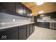 Modern kitchen featuring dark cabinetry, attractive countertops, stainless steel appliances, and tiled floors at 1808 Raible Ave, Anderson, IN 46011