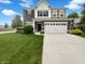 Inviting two-story home featuring a two-car garage and well-maintained front lawn at 18230 Sandy Cove Ln, Westfield, IN 46074