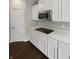 Bright kitchen boasts white cabinets, quartz countertops, stainless appliances, and an electric cooktop at 18230 Sandy Cove Ln, Westfield, IN 46074
