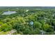Aerial view of property in a heavily wooded neighborhood with a nearby lake at 2120 Wynnedale Rd, Indianapolis, IN 46228