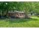 Secluded backyard featuring a stone patio, mature trees, and lush landscaping at 2120 Wynnedale Rd, Indianapolis, IN 46228
