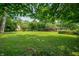 Expansive grassy backyard surrounded by mature trees, offering privacy and space at 2120 Wynnedale Rd, Indianapolis, IN 46228