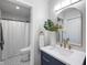 Well-lit bathroom featuring a modern vanity, decorative mirror, and walk-in shower at 2120 Wynnedale Rd, Indianapolis, IN 46228