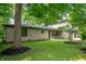 Beautiful side view of home with stone facade, mature trees, and manicured lawn at 2120 Wynnedale Rd, Indianapolis, IN 46228
