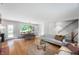 Open-concept living room with dining area featuring wood floors, a fireplace, and stairs to upper level at 2120 Wynnedale Rd, Indianapolis, IN 46228