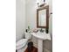 Charming half-bath with pedestal sink, decorative mirror, and elegant fixtures at 2191 Greencroft St, Carmel, IN 46032