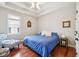 This bedroom has a window, cherry hardwood floors, a bed, and an accent chair with ottoman at 2191 Greencroft St, Carmel, IN 46032