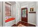 Bright entryway featuring a storage bench with a dark wood door and hardwood floors at 2191 Greencroft St, Carmel, IN 46032