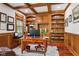 Office featuring built-in shelves and cabinets, with hardwood floors and wooden desk at 2191 Greencroft St, Carmel, IN 46032