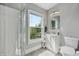 Bright bathroom showcasing a shower, window, vanity with storage, and toilet at 2229 N Arsenal Ave, Indianapolis, IN 46218