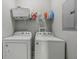 Convenient laundry room with washer, dryer, shelving and neutral gray walls at 2229 N Arsenal Ave, Indianapolis, IN 46218