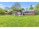 A large, expansive backyard features a covered patio, well-kept lawn and mature trees at 2309 Alexandria Dr, Greenfield, IN 46140
