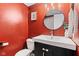 Bathroom with red walls features a modern sink, vanity, mirror, and toilet at 2309 Alexandria Dr, Greenfield, IN 46140