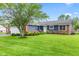 Exterior view of a well-maintained home featuring a blue facade, brick accents, and a lush front yard landscape at 2309 Alexandria Dr, Greenfield, IN 46140