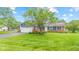 Exterior view of a well-maintained home featuring a blue facade, brick accents, and a lush front yard landscape at 2309 Alexandria Dr, Greenfield, IN 46140