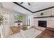 Bright living room with fireplace, exposed beams, mounted television and seamless flow into sunroom at 2309 Alexandria Dr, Greenfield, IN 46140