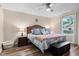Cozy main bedroom features a comfortable queen-sized bed, wood flooring, and a bright window at 2309 Alexandria Dr, Greenfield, IN 46140