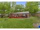 Large backyard with a well-maintained lawn, a deck, and mature trees provides a serene outdoor space at 2397 Lincoln Dr, Cicero, IN 46034