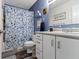 Bathroom with a shower-tub combination, vanity with white cabinetry, and blue-accented walls at 2397 Lincoln Dr, Cicero, IN 46034