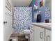 Well-lit bathroom features a shower-tub with a floral curtain and white vanity, accented with a blue wall at 2397 Lincoln Dr, Cicero, IN 46034
