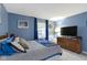 Comfortable bedroom with a queen-sized bed, wood dresser, and curtains framing the bright window at 2397 Lincoln Dr, Cicero, IN 46034
