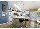 Bright kitchen boasts white cabinets, skylight, unique glass block island with bar seating, and wood flooring at 2397 Lincoln Dr, Cicero, IN 46034