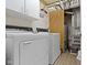 Functional laundry room equipped with modern washer and dryer units and overhead storage cabinets at 2397 Lincoln Dr, Cicero, IN 46034
