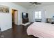 Relaxing bedroom featuring dark floors, a ceiling fan, and natural light from a large window at 2717 Arklow Way, Brownsburg, IN 46112