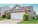 Two-car garage with vinyl siding, brick accents, and an American flag at 2911 W Hawanian Ln, Monrovia, IN 46157