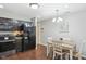 Bright kitchen featuring stainless steel appliances, dark cabinetry, and hardwood flooring, next to a dining area at 2911 W Hawanian Ln, Monrovia, IN 46157