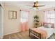 Bright bedroom features a ceiling fan, single bed, carpeted floor, and windows with pink sheer curtains at 2956 N 700 E, Franklin, IN 46131
