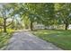 Long gravel driveway leading to a ranch-style home surrounded by mature trees at 2956 N 700 E, Franklin, IN 46131
