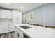 Bright kitchen featuring an island breakfast bar, wooden chairs, and views into the laundry room at 2956 N 700 E, Franklin, IN 46131