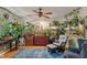 Sun-filled living room featuring vibrant plants, a comfortable glider chair, and a stylish ceiling fan at 3631 S 450 E, Whitestown, IN 46075