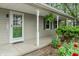 Charming covered porch with green door, white columns and hanging plants at 3631 S 450 E, Whitestown, IN 46075