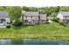 Aerial view of a home with a large green yard, a deck, and a pond with lush greenery at 3708 Gould Dr, Carmel, IN 46033
