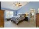 Bright bedroom featuring a ceiling fan, window with blinds, and an ensuite walk-in closet for ample storage at 3708 Gould Dr, Carmel, IN 46033