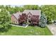 Beautiful brick home with mature trees and a well-manicured lawn overlooking a serene pond at 3708 Gould Dr, Carmel, IN 46033