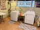 A basement laundry area with a washing machine and dryer, plus a table and shelving at 3745 Winthrop Ave, Indianapolis, IN 46205