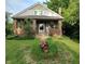 Charming brick home with front porch, lush landscaping, and inviting curb appeal at 3745 Winthrop Ave, Indianapolis, IN 46205