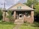 Charming brick home with front porch, lush landscaping, and inviting curb appeal at 3745 Winthrop Ave, Indianapolis, IN 46205