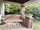 Relaxing front porch with a wooden porch swing and brick pillar creating an inviting outdoor space at 3745 Winthrop Ave, Indianapolis, IN 46205