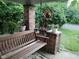 Inviting front porch with a swing and brick pillars adorned with plants and hanging flower decor at 3745 Winthrop Ave, Indianapolis, IN 46205
